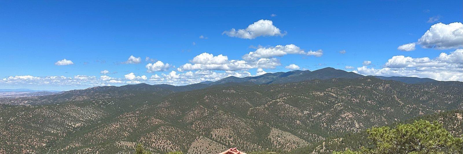 Trail country outside town: pinon and juniper rolling away under a tall sky.