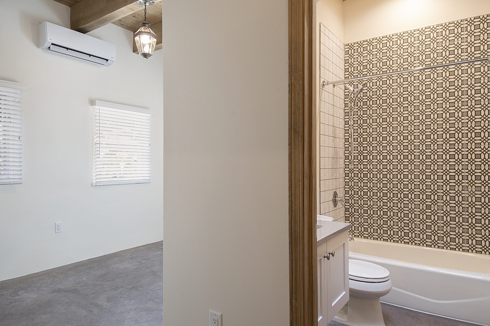 The doorway from Unit B's primary bedroom into its ensuite bathroom, with patterned tile visible beyond.