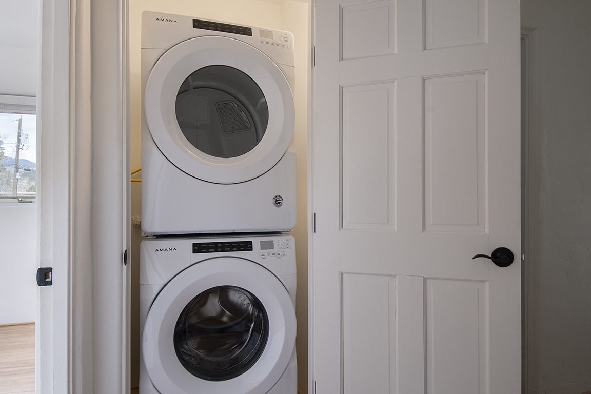 Unit C's own stacked washer and dryer in a hall closet.