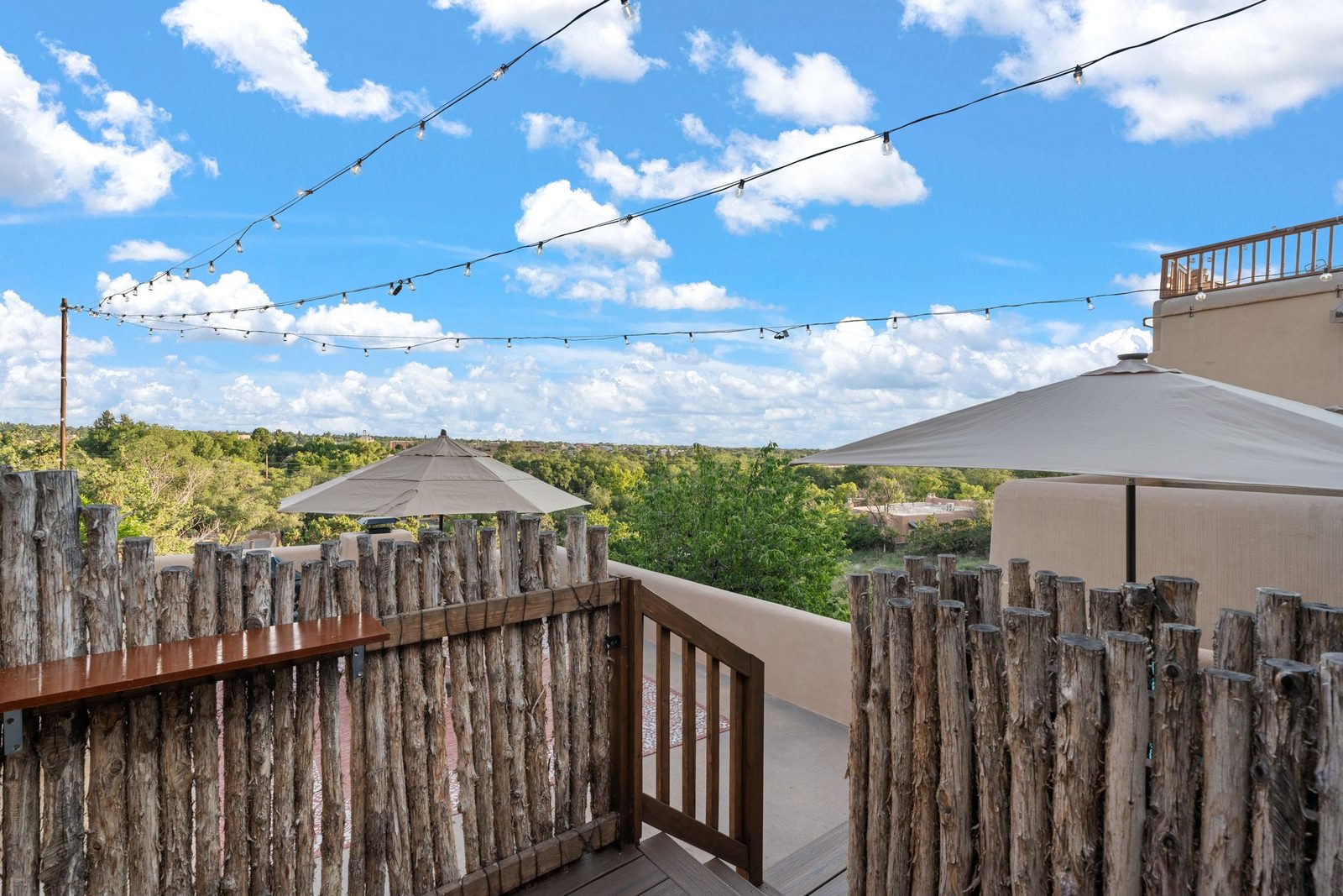 The view from the deck out over downtown Santa Fe, rooftops and treetops running to the ridgeline.