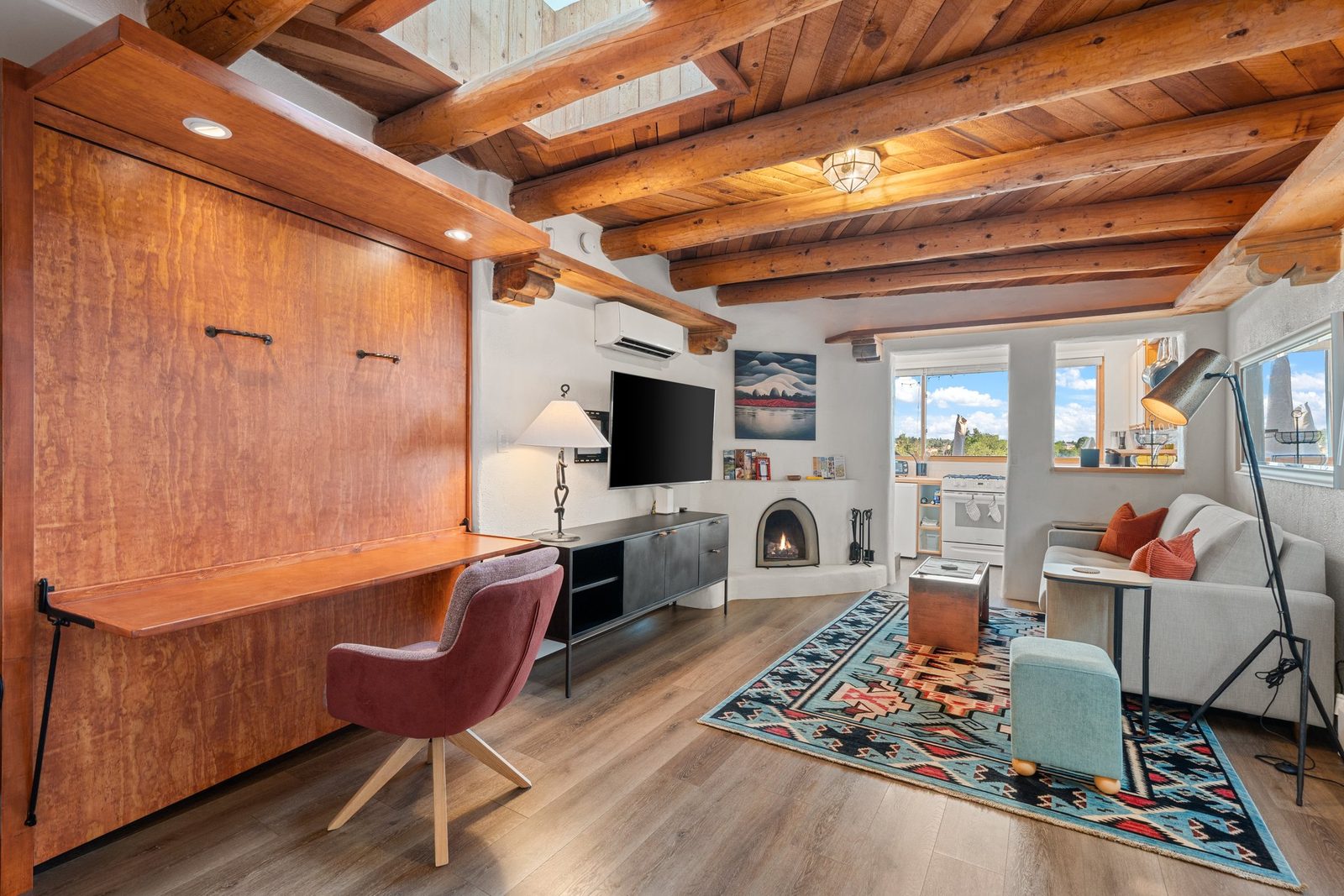The desk built into its wood cabinet with a chair pulled up, ready to work at, the deck windows beyond.