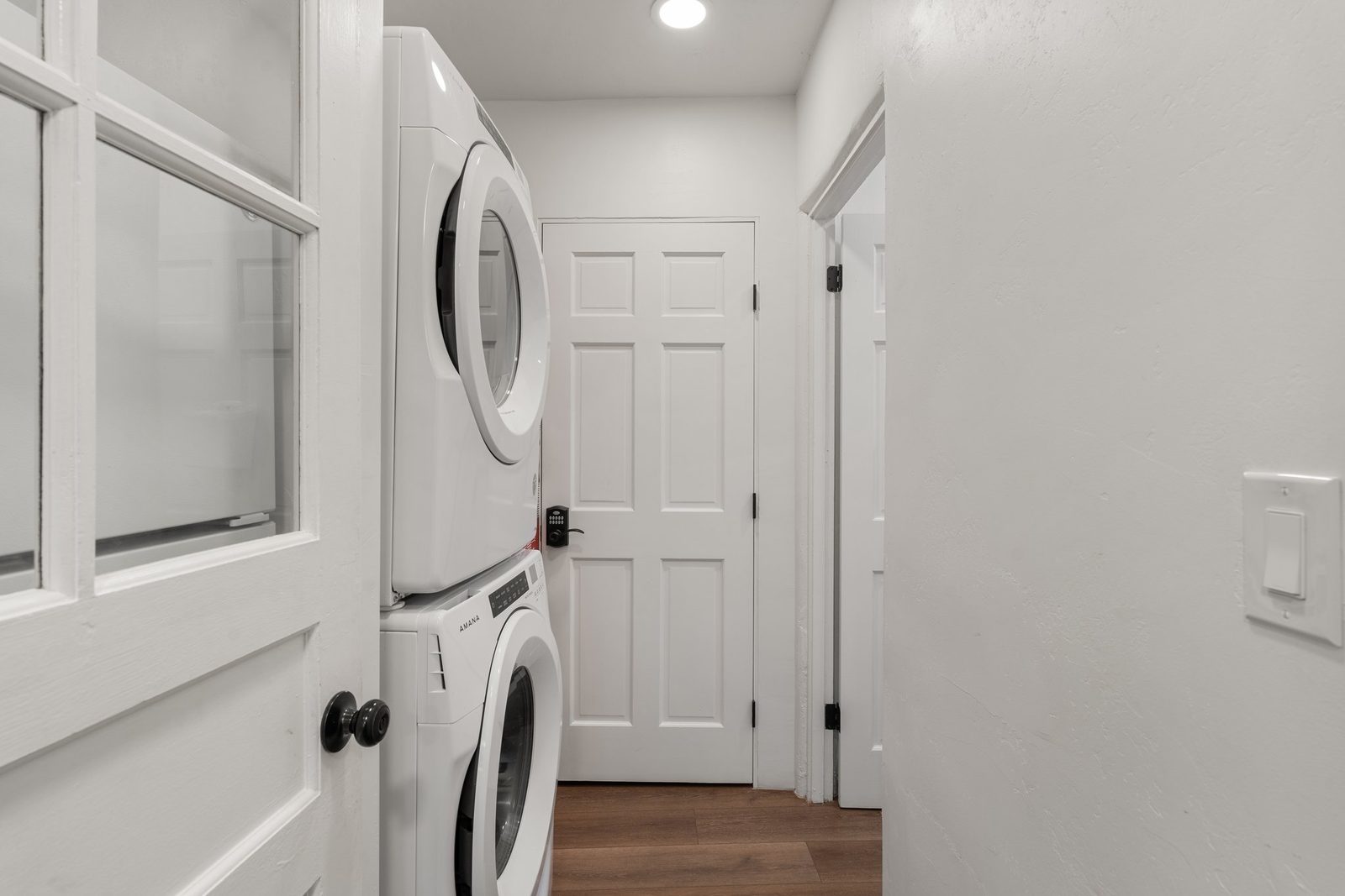 The stacked washer and dryer tucked into their own closet behind a door.