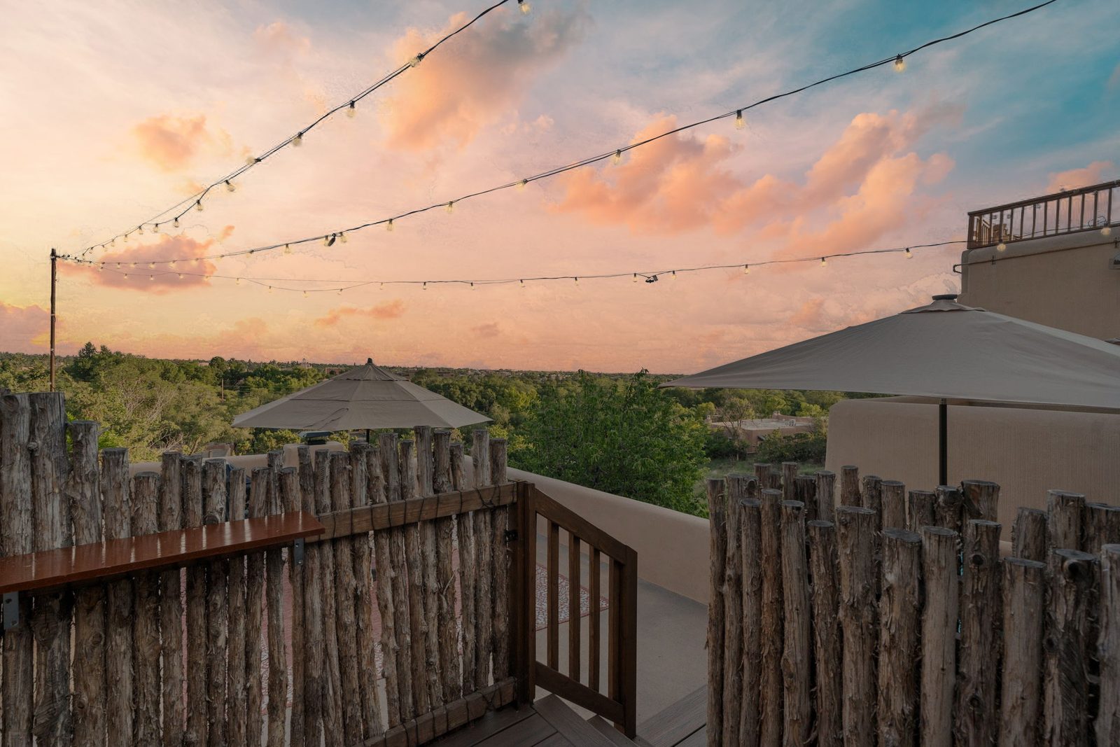 Sunset from the deck, string lights strung above the coyote fencing and the sky going pink over the mountains.